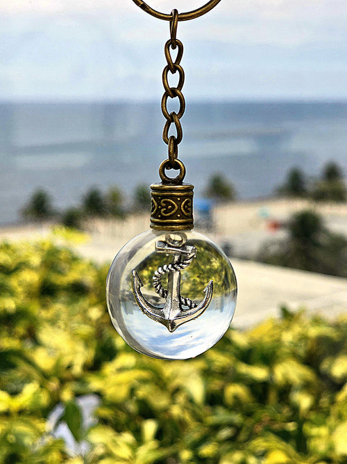 Anchor of Atlantis resin orb keychain — beach and ocean backdrop
