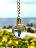 Bone Valley fossilized mako shark tooth suspended in a clear resin orb keychain with an ocean backdrop